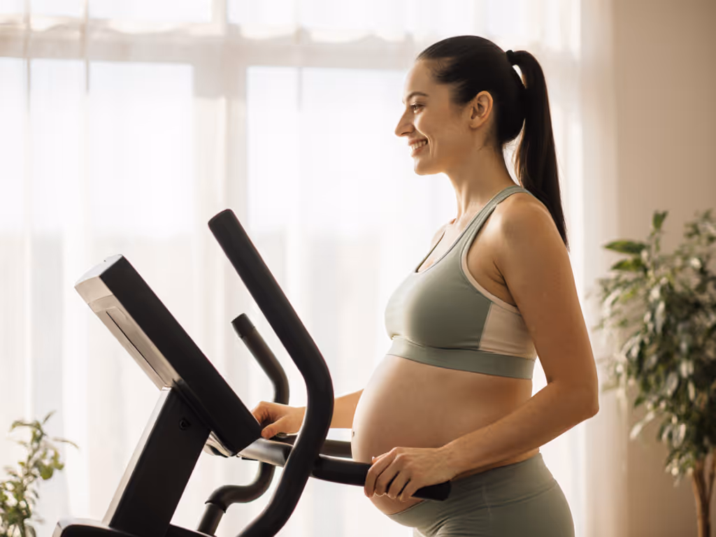 woman_smiling_while_using_elliptical_with_hands_lightly_touching_handles